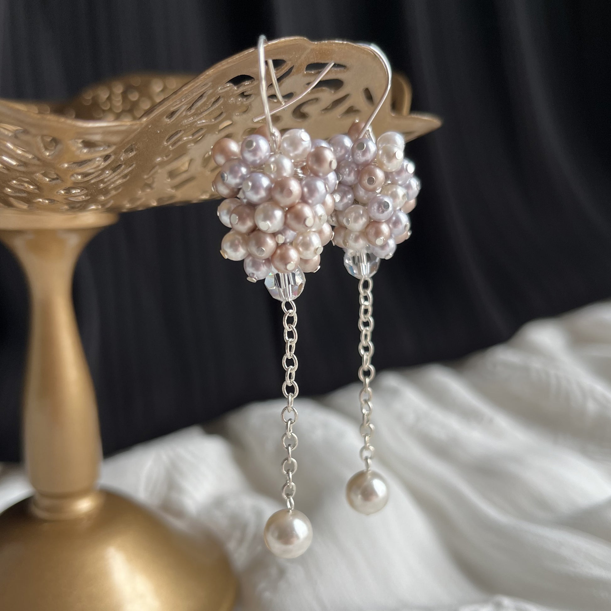 Lavender and almond pearl earrings in close side view on brass stand, softly romantic and handcrafted.